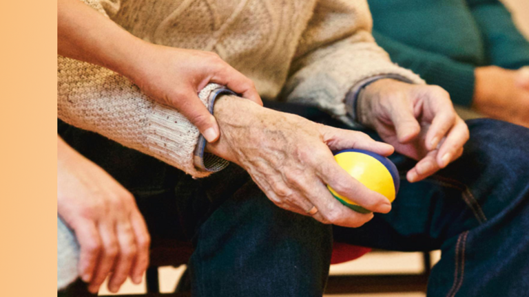 Jüngere Hände und ältere Hände mit einem kleinen Ball.
