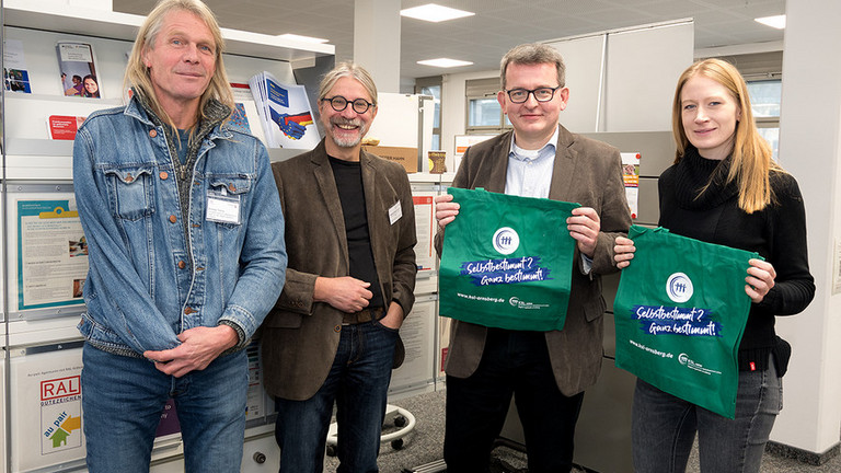 Am Stand der KSL im Gespräch: v.l. Andreas Tinturp (Projektltg. KSL Arnsberg), Michael Kalthoff-Mahnke (Referent, KSL NRW MSi), Oliver Schmale (Ltg. Arbeitsagentur Meschede-Soest) und Carolina Wolf