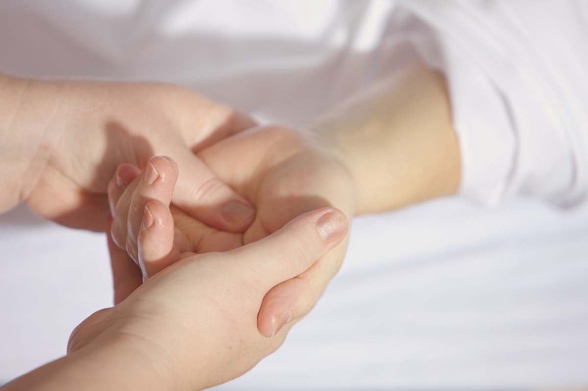 Zwei junge Hände streicheln die Hand eines älteren Menschen.