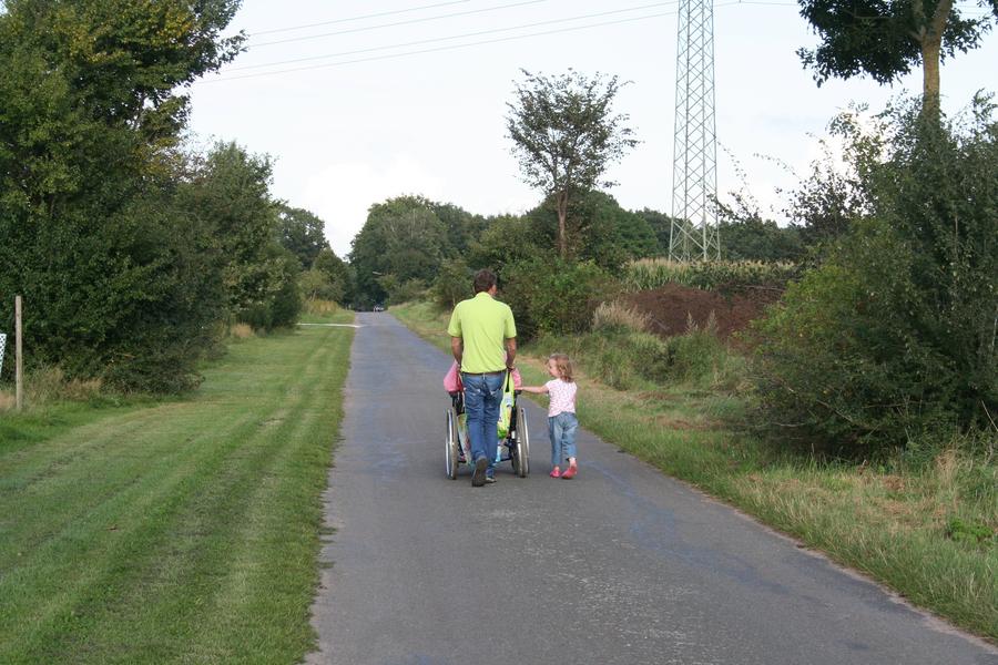 Mutter im Rollstuhl, Vater und Kind auf Parkweg